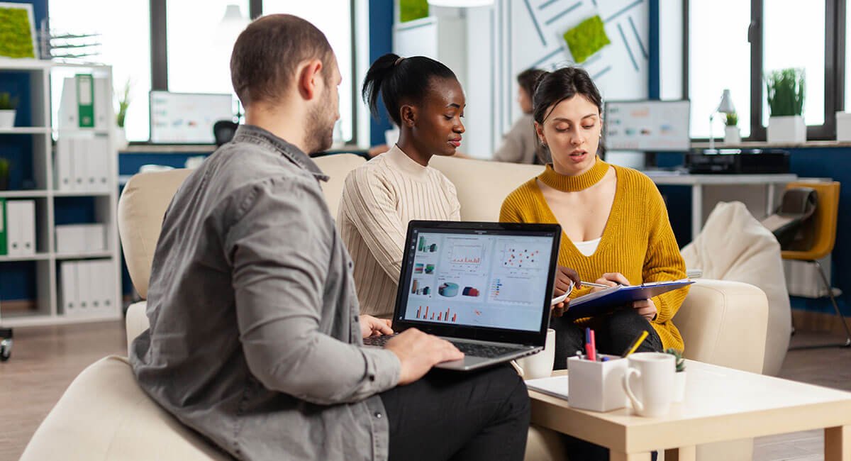 Beraterin und Kunden besprechen eine Online-Finanzierung am Laptop